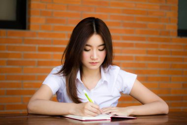 Taylandlı yetişkin öğrenci üniformasının portresi. Güzel kız. Kitap yaz.