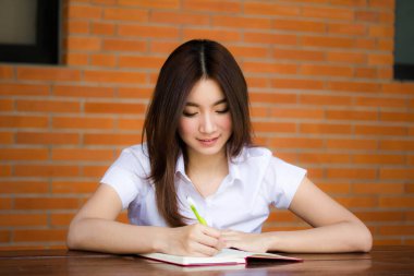 Taylandlı yetişkin öğrenci üniformasının portresi. Güzel kız. Kitap yaz.