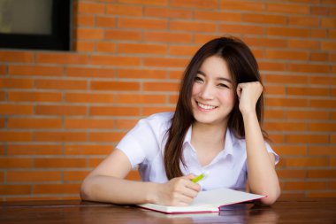 Taylandlı yetişkin öğrenci üniformasının portresi. Güzel kız. Kitap yaz.