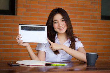 Taylandlı yetişkin öğrenci üniforması tabletini kullanan güzel bir kızın portresi..