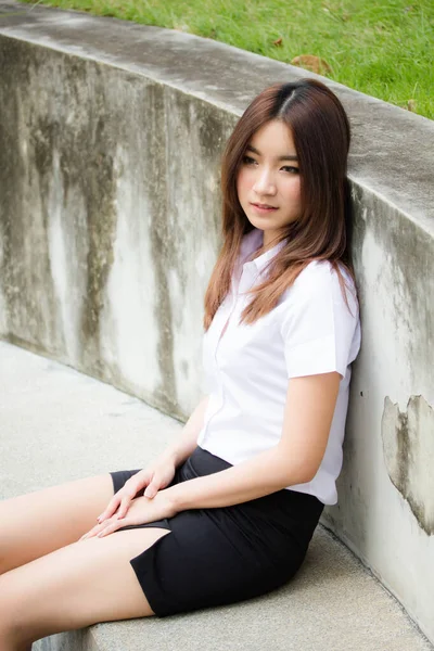 Taylandlı yetişkin öğrenci üniforması portresi. Güzel kız rahatla ve gülümse.