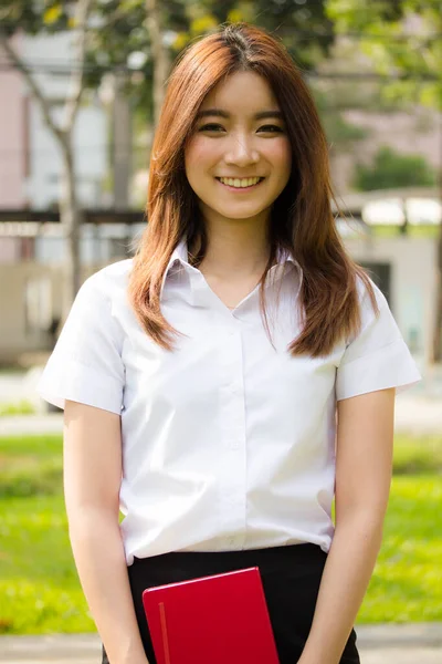 Taylandlı yetişkin öğrenci üniforması portresi. Güzel kız rahatla ve gülümse.