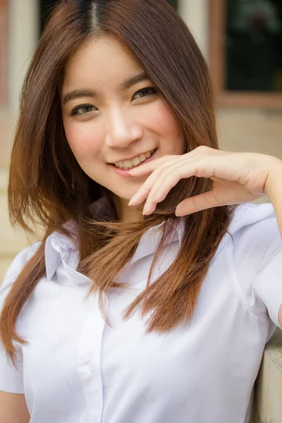 Taylandlı yetişkin öğrenci üniforması portresi. Güzel kız rahatla ve gülümse.