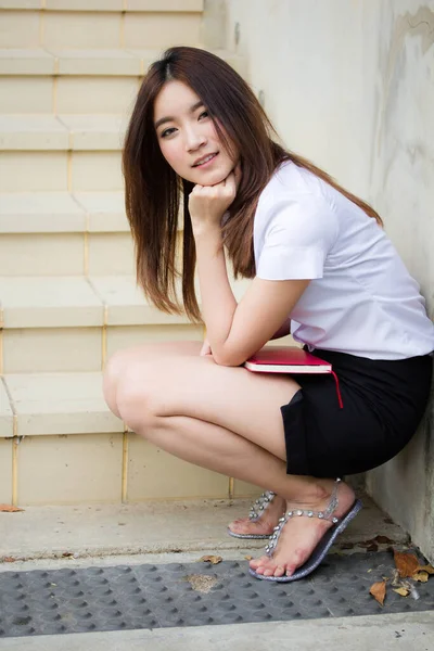 Taylandlı yetişkin öğrenci üniforması portresi. Güzel kız rahatla ve gülümse.