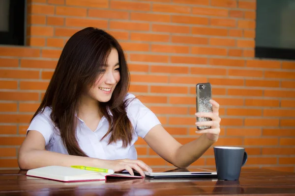 자신의 스마트폰 셀피를 사용하는 타이성 대학생 유니폼을 아름다운 소녀의 — 스톡 사진