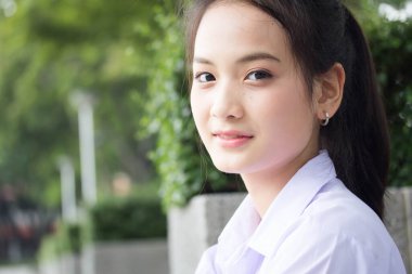 Taylandlı liseli üniformasının portresi. Genç güzel kız mutlu ve rahat.