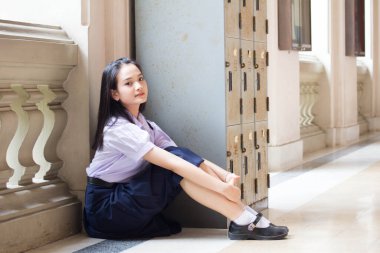 Taylandlı liseli üniformasının portresi. Genç güzel kız mutlu ve rahat.