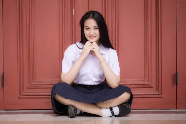 Taylandlı liseli üniformasının portresi. Genç güzel kız mutlu ve rahat.