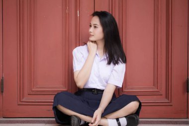 Taylandlı liseli üniformasının portresi. Genç güzel kız mutlu ve rahat.