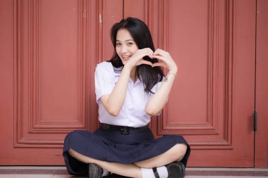 Taylandlı liseli üniformasının portresi. Genç güzel kız mutlu ve rahat.