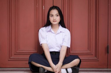 Taylandlı liseli üniformasının portresi. Genç güzel kız mutlu ve rahat.