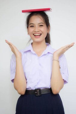 Asya Taylandlı lise öğrencisi üniforması. Güzel kız bir kitap okumuş.