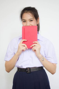 Asya Taylandlı lise öğrencisi üniforması. Güzel kız bir kitap okumuş.
