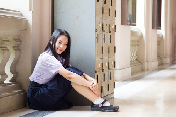 Taylandlı liseli üniformasının portresi. Genç güzel kız mutlu ve rahat.