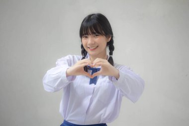 Taylandlı liseli üniformasının portresi. Güzel bir kız kalbini verir.