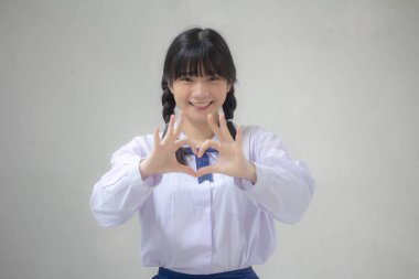 Taylandlı liseli üniformasının portresi. Güzel bir kız kalbini verir.