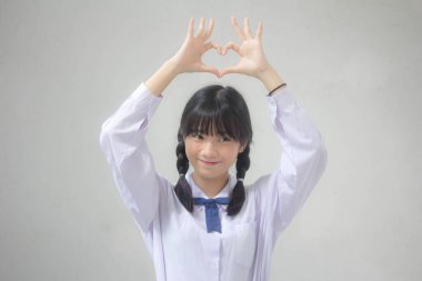 Taylandlı liseli üniformasının portresi. Güzel bir kız kalbini verir.