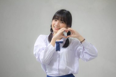 Taylandlı liseli üniformasının portresi. Güzel bir kız kalbini verir.