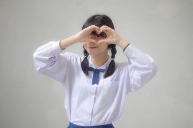 Taylandlı liseli üniformasının portresi. Güzel bir kız kalbini verir.