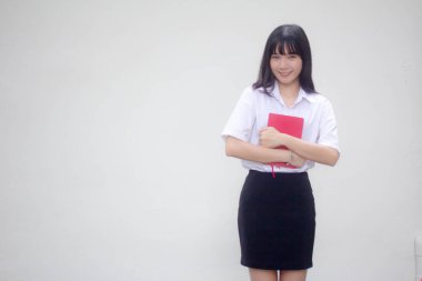 Taylandlı yetişkin üniversite üniforması güzel kız ve kırmızı kitap.