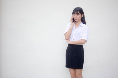 Yetişkin öğrenci üniforması. Güzel bir kız. Akıllı telefondan arıyor.