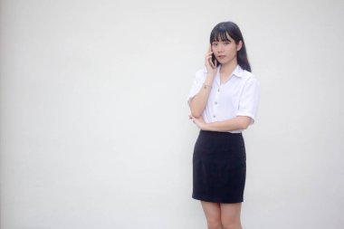 Yetişkin öğrenci üniforması. Güzel bir kız. Akıllı telefondan arıyor.