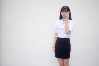 Yetişkin öğrenci üniforması. Güzel bir kız. Akıllı telefondan arıyor.