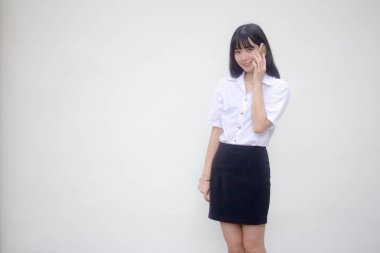 Yetişkin öğrenci üniforması. Güzel bir kız. Akıllı telefondan arıyor.