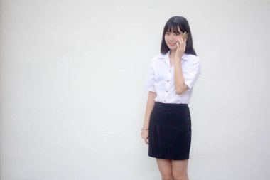 Yetişkin öğrenci üniforması. Güzel bir kız. Akıllı telefondan arıyor.