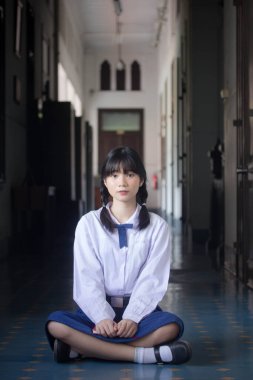 Taylandlı liseli üniformasının portresi. Genç güzel kız mutlu ve rahat.