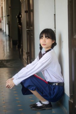 Taylandlı liseli üniformasının portresi. Genç güzel kız mutlu ve rahat.