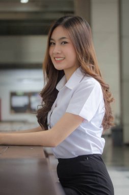 Taylandlı yetişkin öğrenci üniforması güzel kız rahatla ve gülümse.