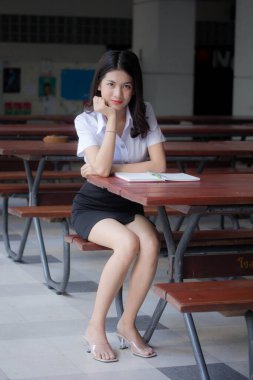 Taylandlı yetişkin öğrenci üniforması güzel kız rahatla ve gülümse.