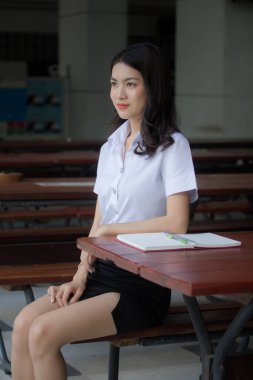 Taylandlı yetişkin öğrenci üniforması güzel kız rahatla ve gülümse.