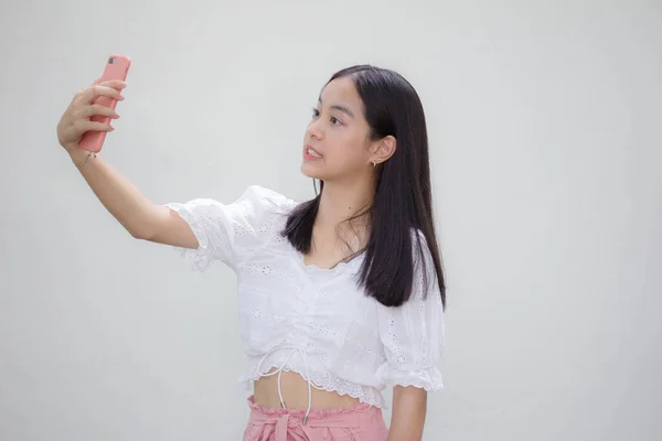 アジアタイティーンホワイトTシャツ美しいです女の子使用して彼女のスマートフォンSelfie — ストック写真