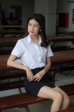 Taylandlı yetişkin öğrenci üniforması güzel kız rahatla ve gülümse.