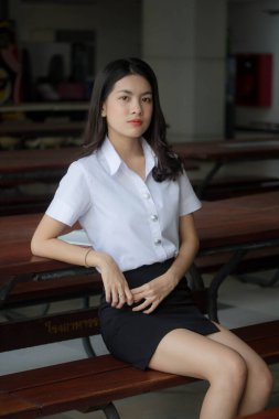 Taylandlı yetişkin öğrenci üniforması güzel kız rahatla ve gülümse.