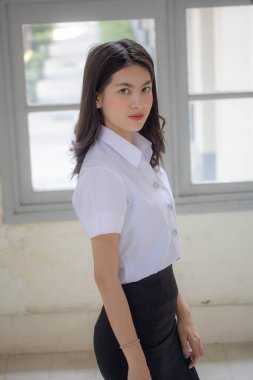 Taylandlı yetişkin öğrenci üniforması güzel kız rahatla ve gülümse.