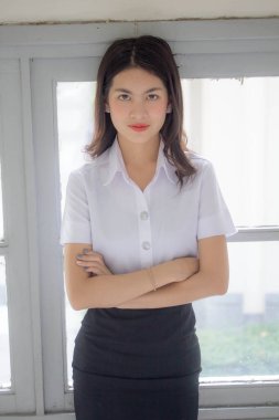 Taylandlı yetişkin öğrenci üniforması güzel kız rahatla ve gülümse.