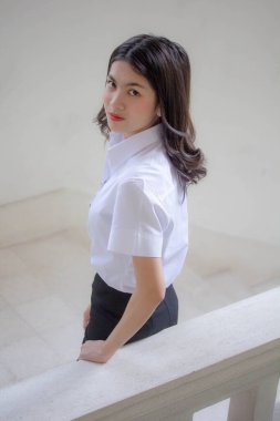 Taylandlı yetişkin öğrenci üniforması güzel kız rahatla ve gülümse.