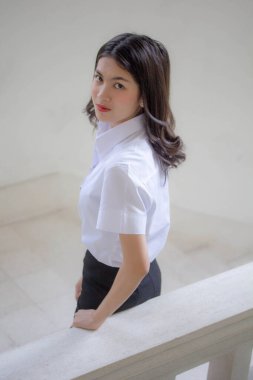 Taylandlı yetişkin öğrenci üniforması güzel kız rahatla ve gülümse.