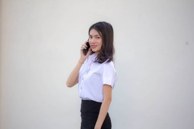 Yetişkin öğrenci üniforması. Güzel bir kız. Akıllı telefondan arıyor.