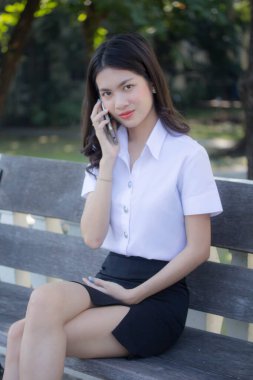 Taylandlı yetişkin öğrenci üniforması güzel kız rahatla ve gülümse.