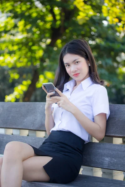 Taylandlı yetişkin öğrenci üniforması güzel kız rahatla ve gülümse.