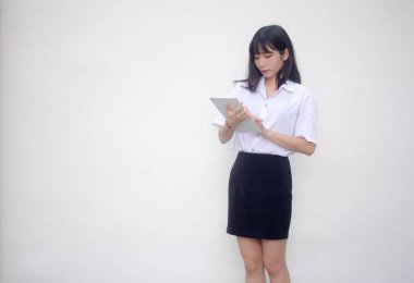 Yetişkin öğrenci üniforması. Tabletini kullanan güzel bir kız..