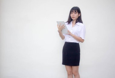 Yetişkin öğrenci üniforması. Tabletini kullanan güzel bir kız..