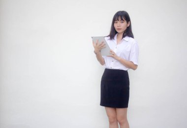 Yetişkin öğrenci üniforması. Tabletini kullanan güzel bir kız..