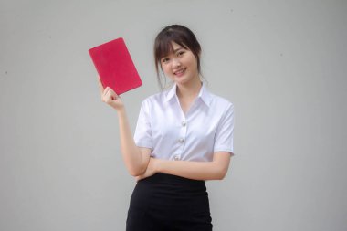 Taylandlı yetişkin öğrenci üniforması güzel kız kırmızı kitap gösteriyor.