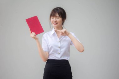 Taylandlı yetişkin öğrenci üniforması güzel kız kırmızı kitap gösteriyor.