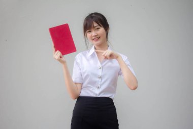 Taylandlı yetişkin öğrenci üniforması güzel kız kırmızı kitap gösteriyor.